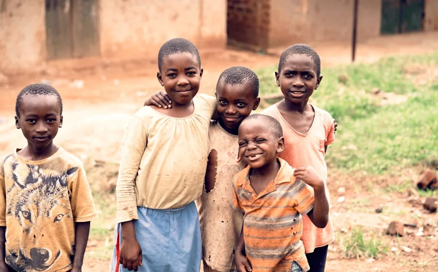 His kids laughing outside school in Kampala